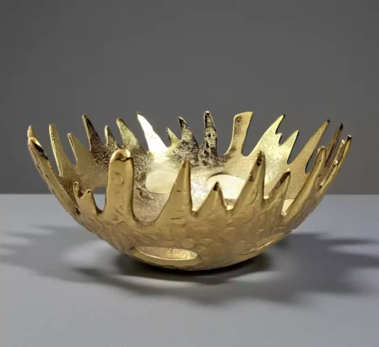 Gold metal bowl with jagged artistic sunburst edge design.