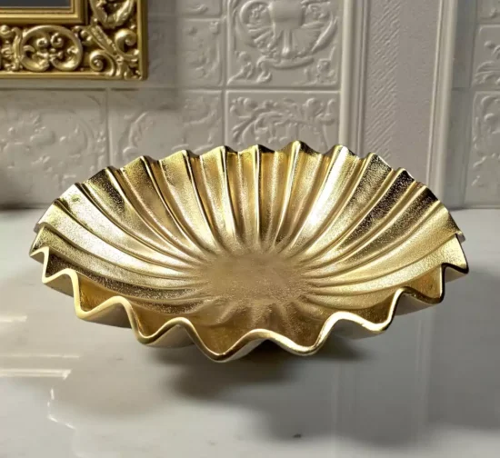 Textured gold metal bowl with wavy scalloped rim design.