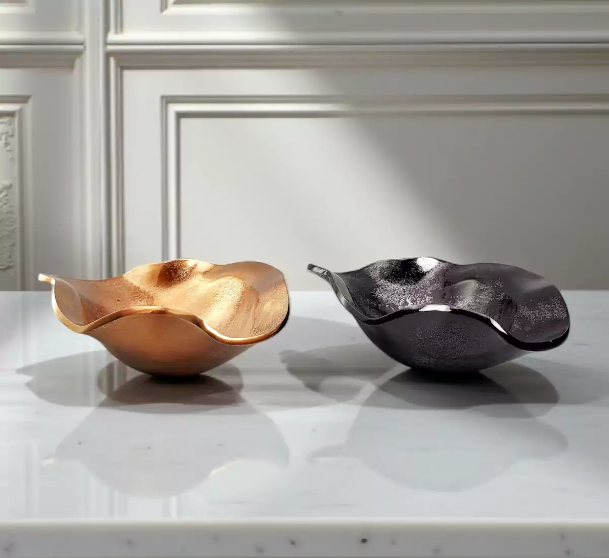 Set of organic wavy metal bowls in gold and black nickel finishes.