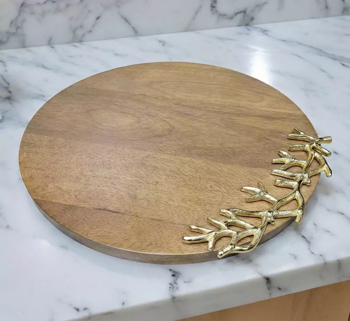 Round wooden serving board with decorative gold aluminum branch accent