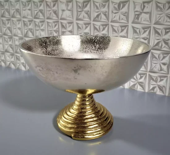 Textured silver metal bowl on a ribbed gold pedestal base.
