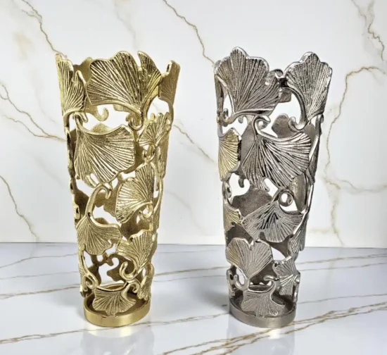 Pair of luxury cutout metal vases in gold and silver with ginkgo leaf design.