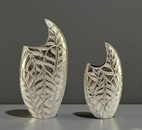 Pair of modern silver metal vases with embossed leaf texture design.